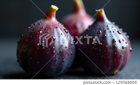 Macro close up of fresh ripe purple figs with water droplets as a healthy concept Macro close up of fresh ripe purple figs with water droplets as a healthy concept 129368609