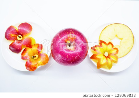 Two kinds of apples cut into the shape of flowers and a cute apple cut into a star shape on a white background 129369838