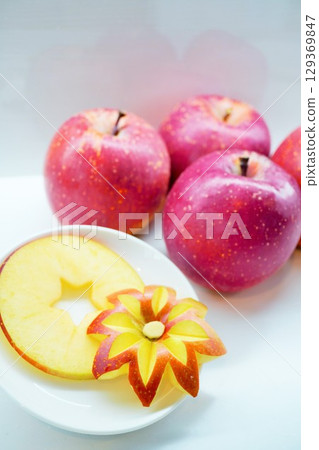 Beautiful apples cut into the shape of a flower on a white background Beautiful apples cut into the shape of a flower on a white background 129369847