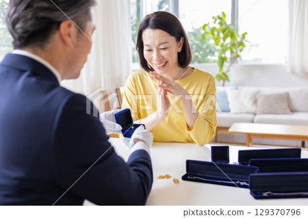 On-site purchase: A housewife having her items appraised at home On-site purchase: A housewife having her items appraised at home 129370796