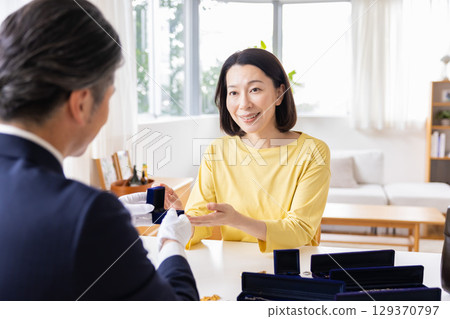 現場購買:一位家庭主婦正在家中評估她的物品 現場購買:一位家庭主婦正在家中評估她的物品 129370797