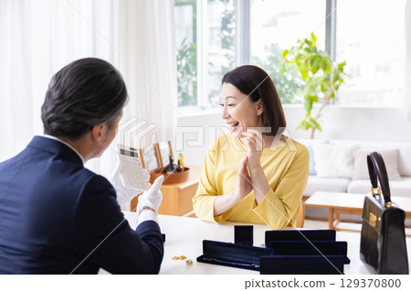 On-site purchase: A housewife having her items appraised at home 129370800