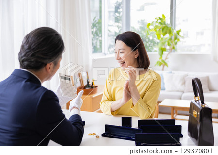 現場購買:一位家庭主婦正在家中評估她的物品 現場購買:一位家庭主婦正在家中評估她的物品 129370801