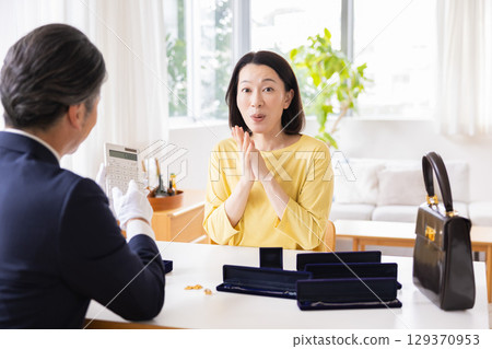 On-site purchase: A housewife having her items appraised at home 129370953