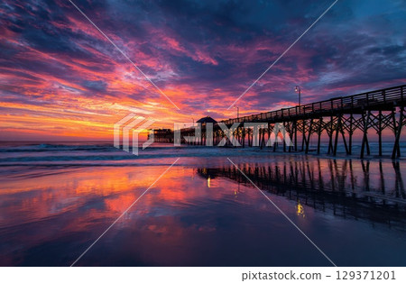 colorful sunrise over the beach with a pier. colorful sunrise over the beach with a pier. 129371201