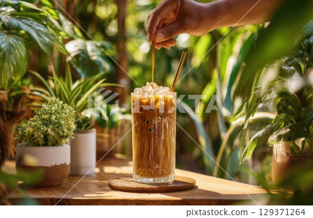iced coffee being served in front view, with the barista hand. 129371264