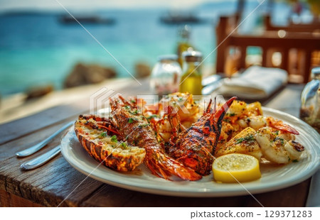 plate of fresh, grilled seafood with prawns and lobster on the beach in sunny Caribbean island 129371283
