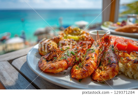 plate of fresh, grilled seafood with prawns and lobster on the beach in sunny Caribbean island 129371284
