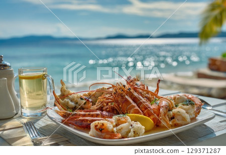 plate of fresh, grilled seafood with prawns and lobster on the beach in sunny Caribbean island 129371287