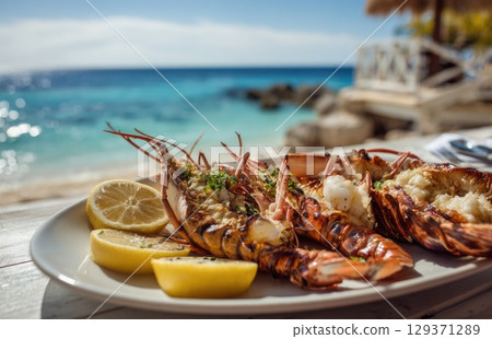 plate of fresh, grilled seafood with prawns and lobster on the beach in sunny Caribbean island plate of fresh, grilled seafood with prawns and lobster on the beach in sunny Caribbean island 129371289