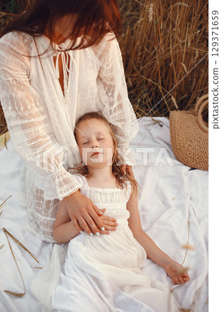 Family in a summer field. Sensual photo. Cute little girl. Woman in a white dress. Family in a summer field. Sensual photo. Cute little girl. Woman in a white dress. 129371659