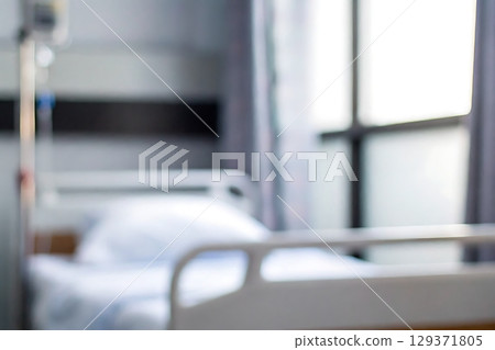 Blurred Hospital Room Interior with Empty Bed and Soft Lighting in Healthcare Setting 129371805
