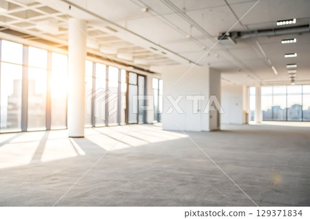 Bright Modern Office Interior with Sunlight Streaming Through Large Windows 129371834