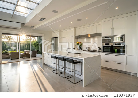 Modern Bright Kitchen Interior with Large Windows and Sunset Light Reflection 129371937