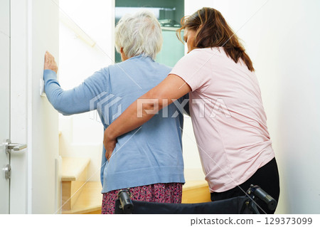 Caregiver help Asian elderly woman disability patient sitting on wheelchair in hospital. Caregiver help Asian elderly woman disability patient sitting on wheelchair in hospital. 129373099