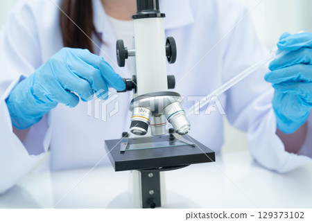 Scientist medical professional use microscope for research in science laboratory. 129373102