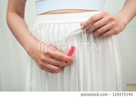 Asian holding pregnancy test for female of ovulation day, fetus, maternity, childbirth, birth control. Asian holding pregnancy test for female of ovulation day, fetus, maternity, childbirth, birth control. 129373140