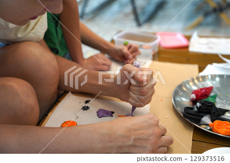 Mother and her daughter paint Halloween cookies Mother and her daughter paint Halloween cookies 129373516