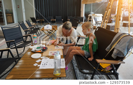 Mother and her daughter paint Halloween cookies Mother and her daughter paint Halloween cookies 129373539