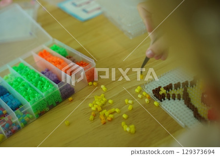 Teacher in workshop teched two girls how to assemble a thermo mosaic Teacher in workshop teched two girls how to assemble a thermo mosaic 129373694