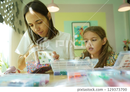 Teacher in workshop teched two girls how to assemble a thermo mosaic Teacher in workshop teched two girls how to assemble a thermo mosaic 129373700