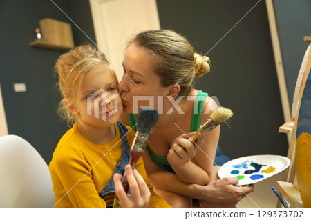 Teacher in workshop teched two girls how to assemble a thermo mosaic  129373702