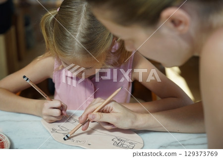 A young mother and her daughter enjoy a creative art session at home A young mother and her daughter enjoy a creative art session at home 129373769
