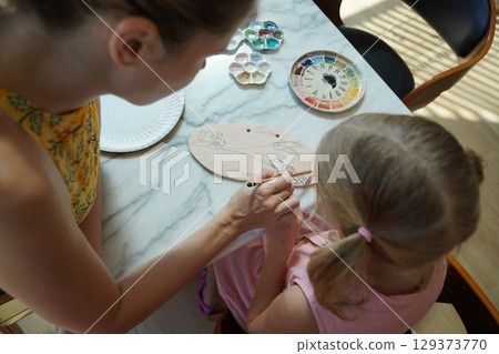 A young mother and her daughter enjoy a creative art session at home  129373770