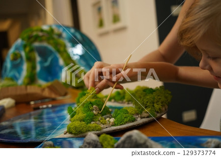 A mother and her daughter craft vibrant natural landscapes  129373774