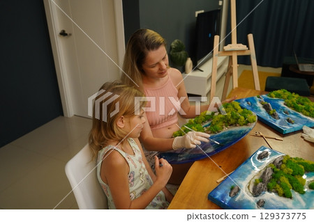 A mother and her daughter craft vibrant natural landscapes A mother and her daughter craft vibrant natural landscapes 129373775