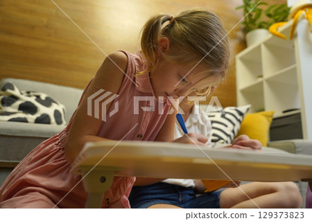 A mother supports her daughter with homework 129373823