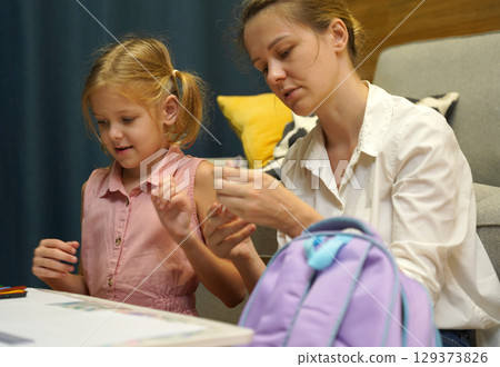 A mother supports her daughter with homework 129373826