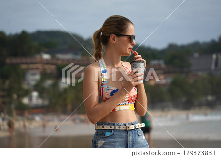 A young woman enjoying a beautiful day at the beach A young woman enjoying a beautiful day at the beach 129373831