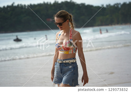 A young woman enjoying a beautiful day at the beach A young woman enjoying a beautiful day at the beach 129373832