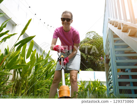 A young woman trims her beautiful garden A young woman trims her beautiful garden 129373860