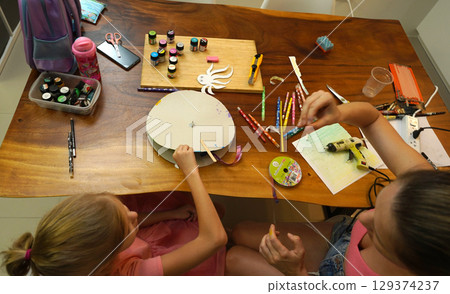 A mother and her young daughter engage in a colorful painting activity A mother and her young daughter engage in a colorful painting activity 129374237