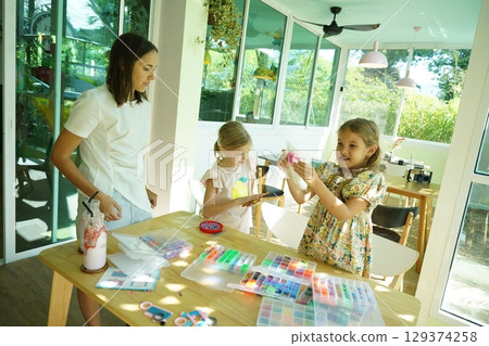Teacher in workshop teched two girls how to assemble a thermo mosaic  129374258