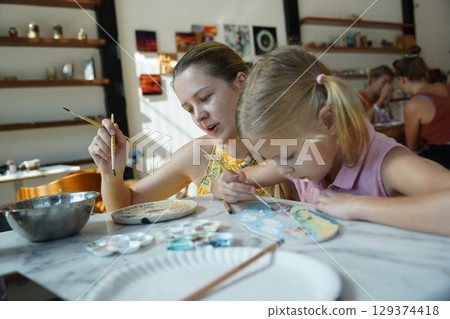 A young mother and her daughter enjoy a creative art session at home  129374418