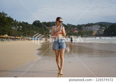 A young woman enjoying a beautiful day at the beach A young woman enjoying a beautiful day at the beach 129374572