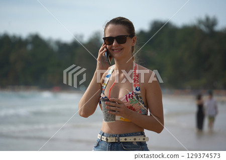 A young woman enjoying a beautiful day at the beach A young woman enjoying a beautiful day at the beach 129374573