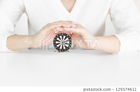Protective Hands Around Dartboard Emphasizing Goal Security and Strategic Focus Protective Hands Around Dartboard Emphasizing Goal Security and Strategic Focus 129374611