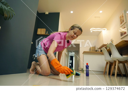 A woman is cleaning her living room at home 129374672