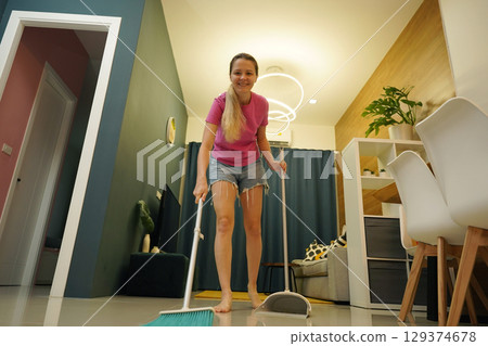 A woman is cleaning her living room at home A woman is cleaning her living room at home 129374678