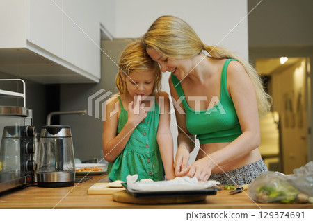 Cooking moments together with mother and daughter at the kitchen 129374691