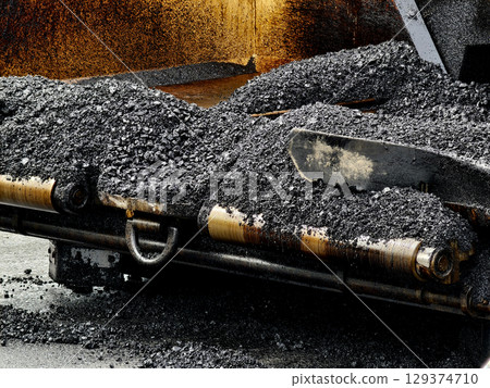 Asphalt paving machine laying down asphalt Asphalt paving machine laying down asphalt 129374710