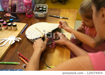 A mother and her young daughter engage in a colorful painting activity A mother and her young daughter engage in a colorful painting activity 129374954