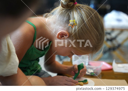 Mother and her daughter paint Halloween cookies Mother and her daughter paint Halloween cookies 129374975