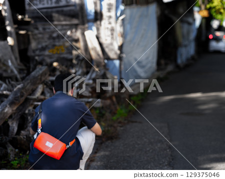 一名男子正在拍攝一個廢棄攤位的照片 一名男子正在拍攝一個廢棄攤位的照片 129375046