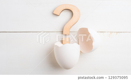 Wooden Question Mark Emerging from Cracked White Egg on Clean Wooden Surface Wooden Question Mark Emerging from Cracked White Egg on Clean Wooden Surface 129375095