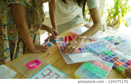Teacher in workshop teched two girls how to assemble a thermo mosaic Teacher in workshop teched two girls how to assemble a thermo mosaic 129375170